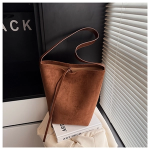 Detailed view of brown suede bucket bag with stylish drawstring tie closure