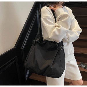 Detail of black canvas tote bag showing adjustable metal buckle and durable material
