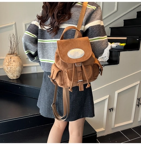 Détail du sac à dos en daim marron avec fermeture à cordon et boucle métallique