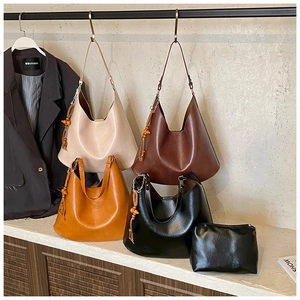 Close-up of textured PU leather bucket bag set with wooden bead tassel and pouch