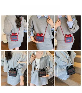 Mini crossbody bags with cherry embroidery and bow details shown on a model