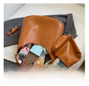 Macro detail of the spacious brown lychee leather bucket bag interior and mini pouch
