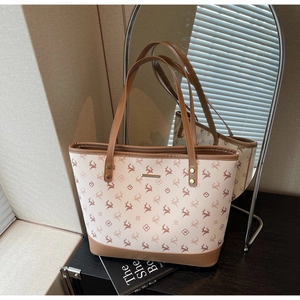 Detail der beigen Vintage-Tragetasche mit Hirschmotiven und braunem Lederbesatz
