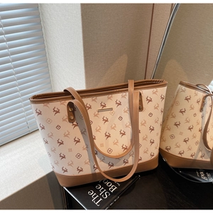 Detailansicht der großen Tote Bag mit Hirsch-Prints und braunen Ledergriffen bei sanftem Licht