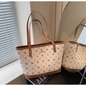 Detail einer großen Shopper-Tasche mit Hirschmuster, Lederbesatz und Goldnieten