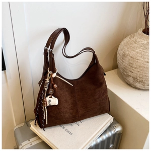 Détail du sac hobo en daim marron café avec boucles en métal et breloque tasse à café