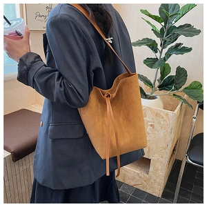 Detail of vintage suede bucket bag with drawstring closure and slim shoulder strap