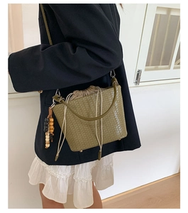 Detail der olivgrünen geflochtenen Beuteltasche mit Holzperlenanhänger und Kordelzugfutter
