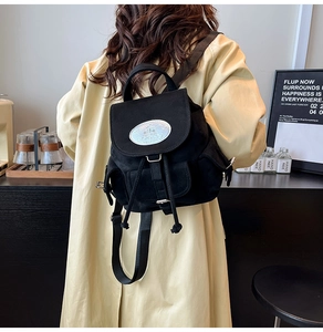 Détails du sac à dos noir en toile avec bretelles réglables et plaque ovale argentée