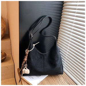 Détail du sac à bandoulière noir mat avec breloque tasse de café et coutures décoratives