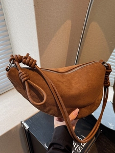 Brown suede crescent bag with knot shoulder strap and minimalist vintage design