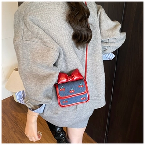 Mini denim crossbody bag with cherry embroidery and oversized red bow detail