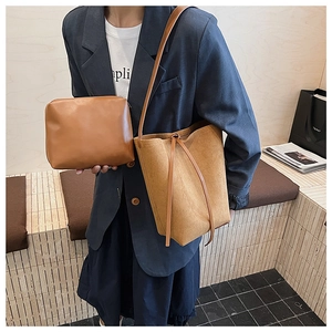 Détail macro du sac seau en daim gingembre avec pochette assortie et cordon de serrage
