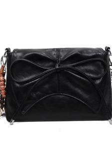 Fashionable black faux leather shoulder bag with large bow and ethnic beaded charm