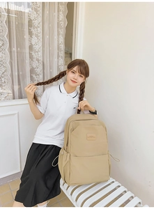 Detail view of khaki minimalist backpack featuring durable fabric and side pockets