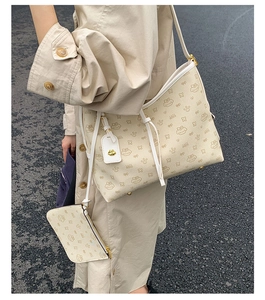 Nahaufnahme der Kontrast-Shopper-Tasche mit Cartoon-Monogramm und Schultergurt