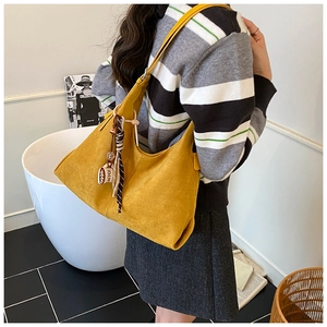 Détail du grand sac cabas jaune en daim avec breloque café et foulard en soie