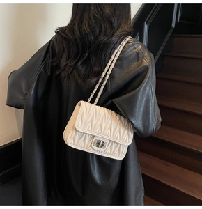 Detailansicht der weißen Stepptasche mit silberner Kette und Metalldrehverschluss