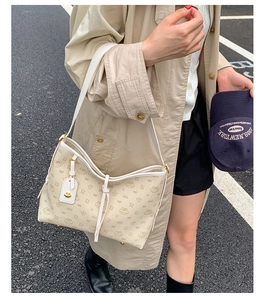 Schicke beige Hobo-Tasche mit Bärenmuster und weißem Lederriemen im Street-Style-Look