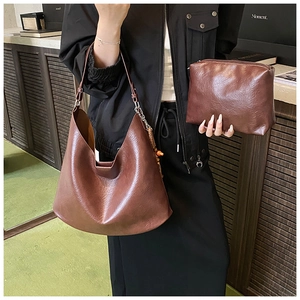 Detail of vintage dark brown faux leather hobo shoulder bag with matching zipper pouch