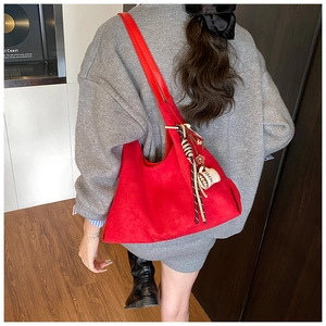 Détail du sac cabas en daim rouge avec breloque tasse à café et lanières tressées