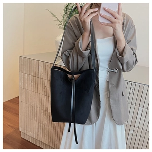 Selfie miroir montrant le sac seau en daim noir porté en bandoulière sur un mannequin
