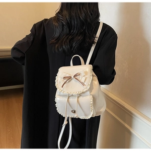 Close-up of cream white PU leather backpack with lace trim and bow knot detail