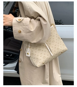Seitenansicht der beigen Beuteltasche mit Hasen-Print getragen zum beigen Trenchcoat