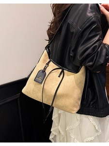 Large khaki suede tote bag with black leather trim and decorative straps for women