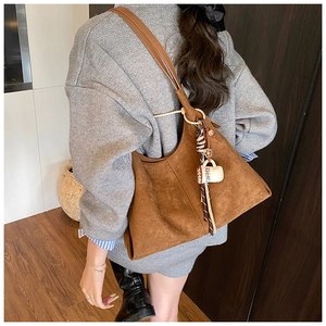 Détail du sac cabas en daim marron avec foulard en soie et pendentif tasse à café