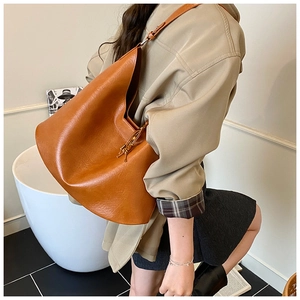 Detail of caramel faux leather tote bag showing soft pebble texture and slouchy design