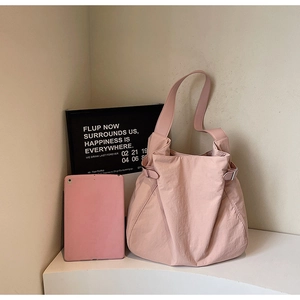 Close-up of pink large capacity tote bag with adjustable metal side buckles and wide strap