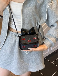 Mini black denim crossbody bag with cherry embroidery and oversized leather bow detail