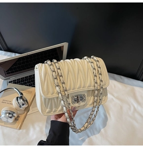 Detail der cremefarbenen Stepptasche mit Silberkette und Strass-Drehverschluss-Schnalle