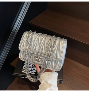 Nahaufnahme der silbernen Matelassé-Handtasche mit Kristallschnalle und Kette