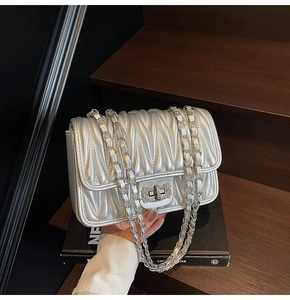 Detail der silbernen gesteppten Handtasche mit Strass-Schnalle und Kettenriemen