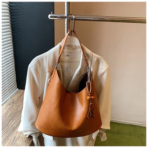 Close-up of brown PU leather bucket bag with litchi texture and wooden bead tassel
