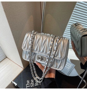 Detailsicht der silbernen Stepptasche mit kristallbesetztem Metalldrehverschluss