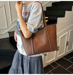 Dettaglio della borsa tote in pelle marrone caramello con texture opaca e tracolla lunga