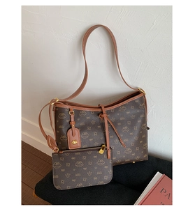 Detailansicht der braunen Monogramm-Einkaufstasche mit Cartoon-Muster und Bienenanhänger