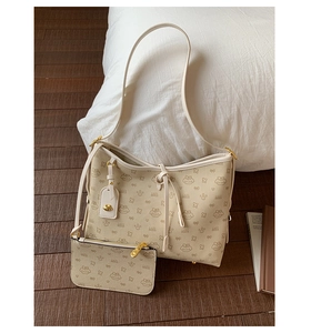 Detailansicht beige Tragetasche Set mit Hasendruck und Goldanhänger auf Holzfußboden