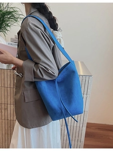 Minimalist Klein blue suede bucket bag with a slim strap for casual shoulder carry