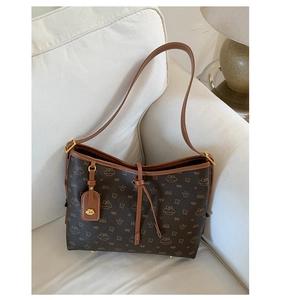 Detailansicht der braunen Bären-Monogramm-Leder und goldener Hardware auf der Tasche