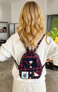 Detalle de una mini mochila de cuadros con cuello de camisa y lindo parche de oso