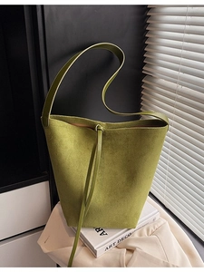 Retro moss green suede bucket bag with leather strap in a minimalist aesthetic