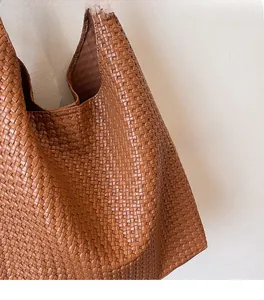 Detailed view of brown woven checkerboard tote bag showing soft vegan leather texture