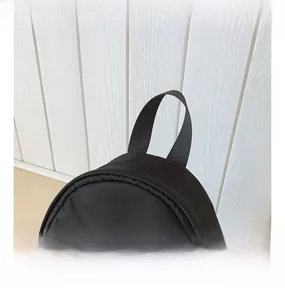 Detail showing high-quality nylon fabric with webbing handle and zipper on black backpack