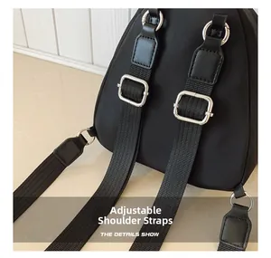 Detail showing adjustable shoulder strap with silver metal buckle on a black backpack