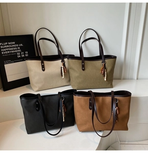 Detailed view of large canvas tote bags in four colors with leather handles and beaded charms