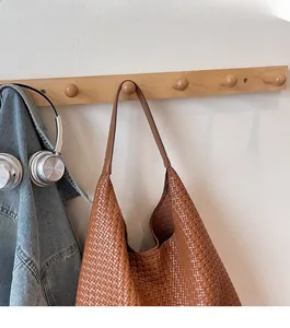 Detail of caramel brown woven leather texture on the spacious hobo shoulder bag